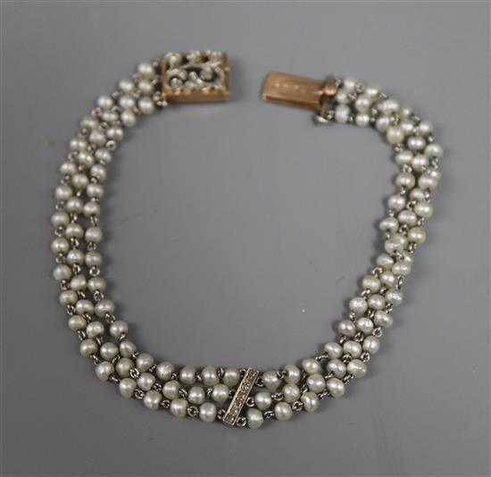 A 1920s? yellow metal, seed pearl and diamond set three strand bracelet, 18.8cm.